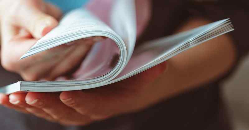 A woman's hands going through the pages of a magazine