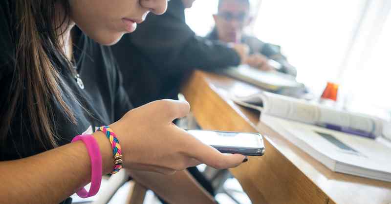 A woman looking at the screen of her phone