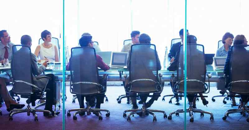 Ten people in a meeting room, sitting opposite each other